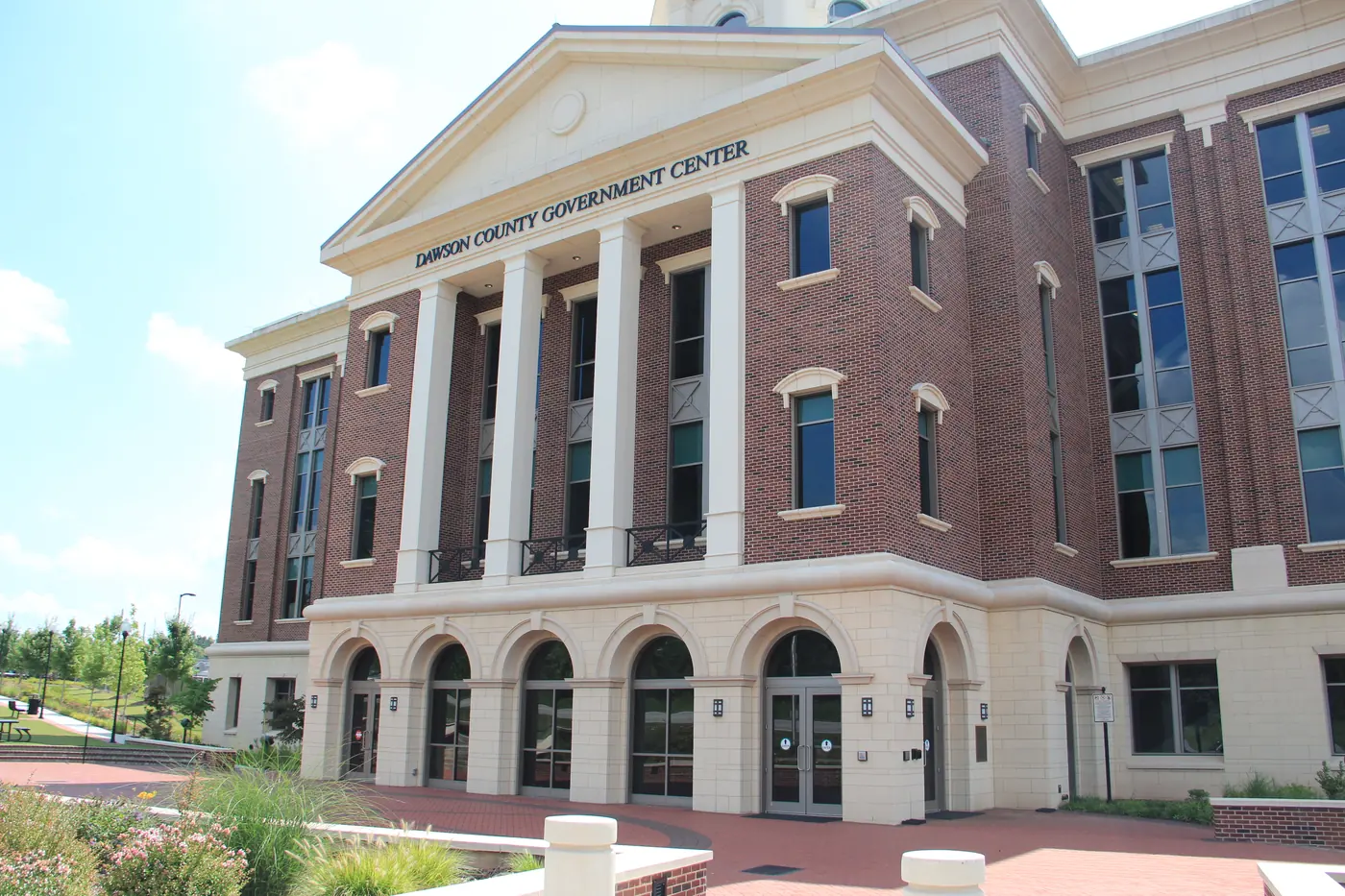 A large red-brick civic building with four white columns under a pediment lettered Dawson County Government Center